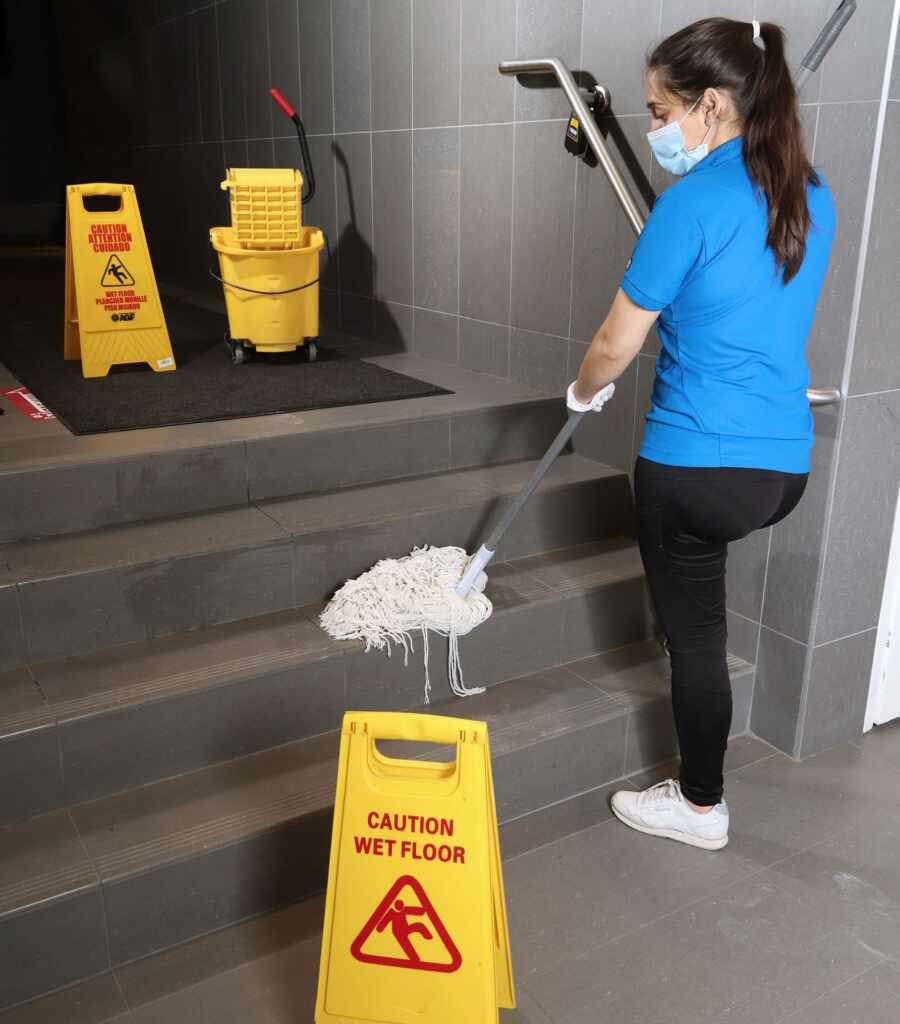 woman performing commercial cleaning services and janitorial services
